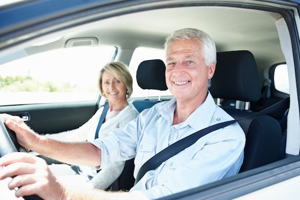 Happy older couple driving a car