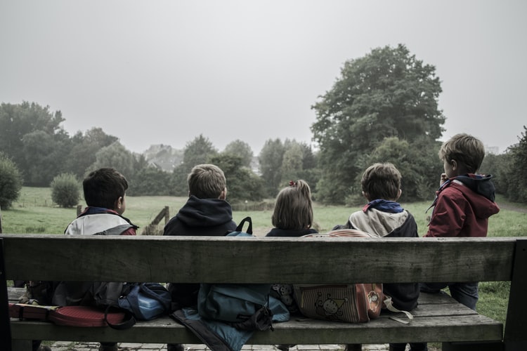 Group of children gather outside.