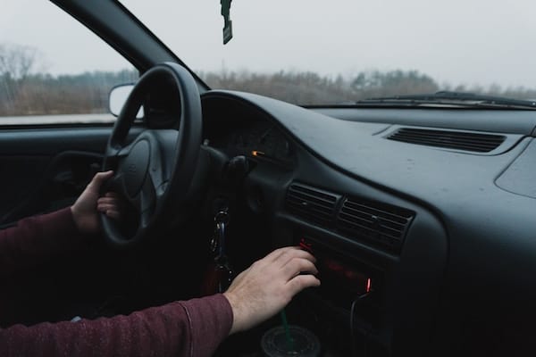 Person driving a car and playing with the stereo 