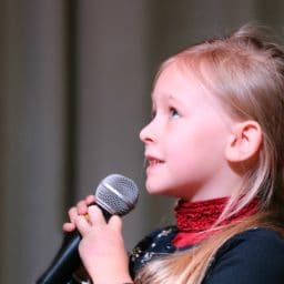 Young girl singing into a microphone 