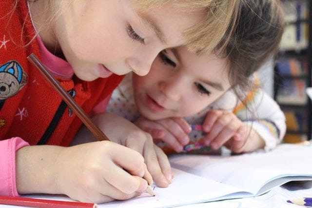 Children writing in a classroom 