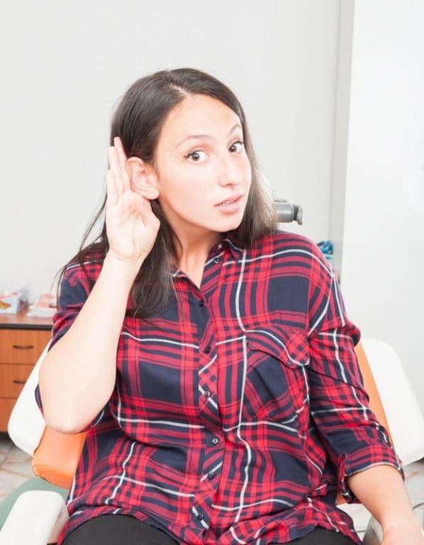 Woman sitting in chair trying to hear something