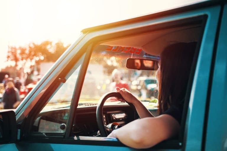 woman driving into sunset