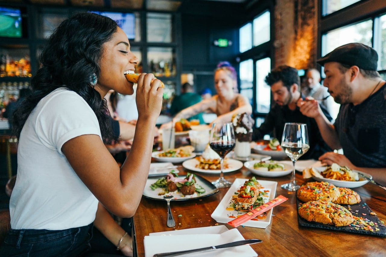 Friends enjoying a meal at a busy restaurant. 