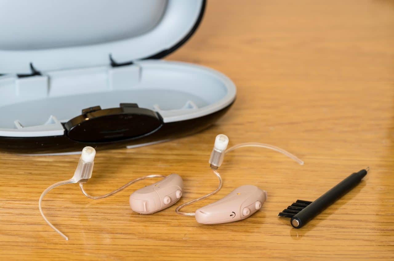 Close up of hearing aids with hearing aid cleaning kit.