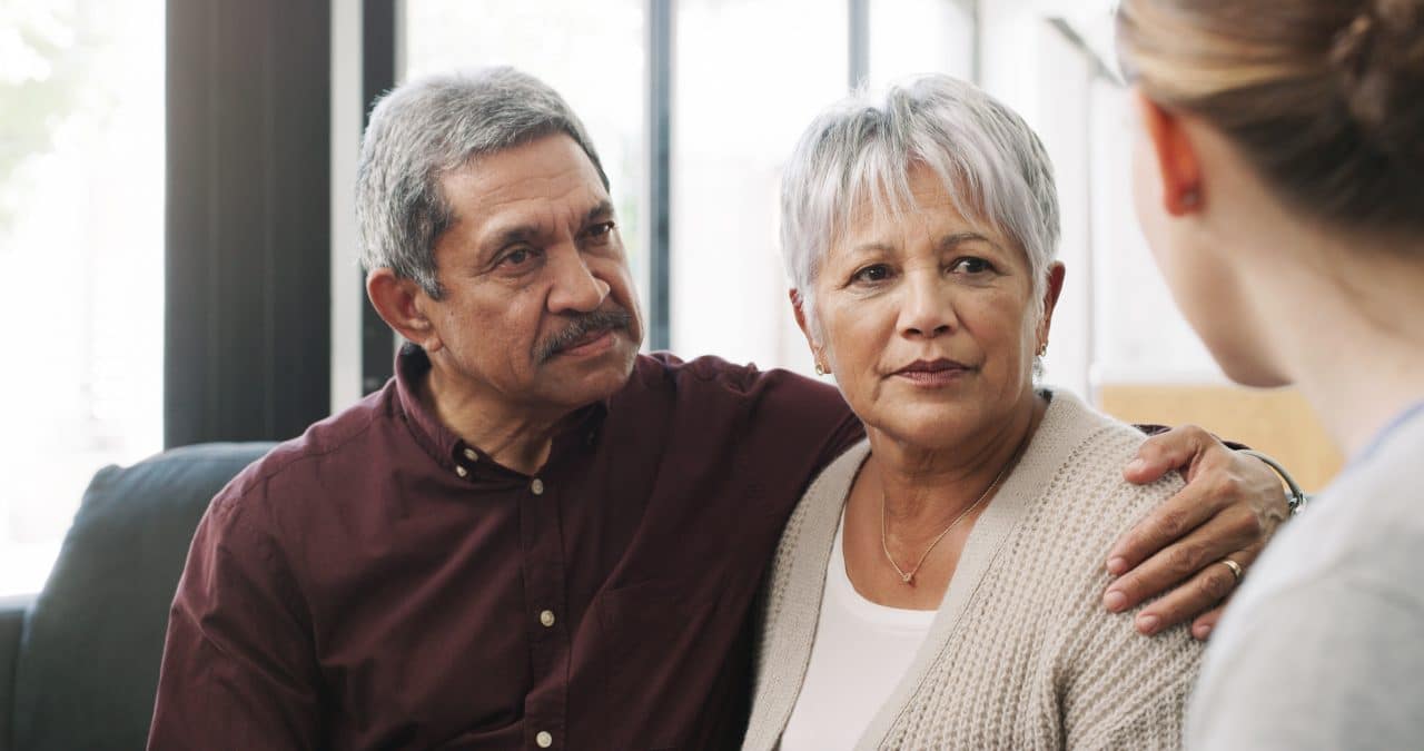 Couple supporting each other during medical appointment.