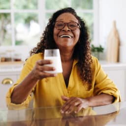 Woman raising a glass of vitamin D fortified milk