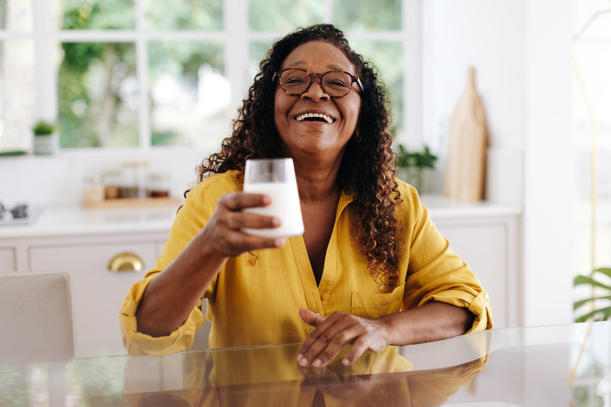 Woman raising a glass of vitamin D fortified milk.