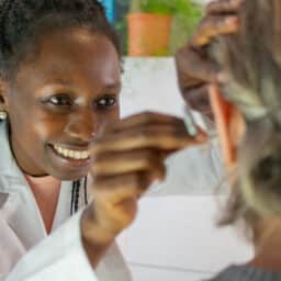 Audiologist fits a patient with a new hearing aid.