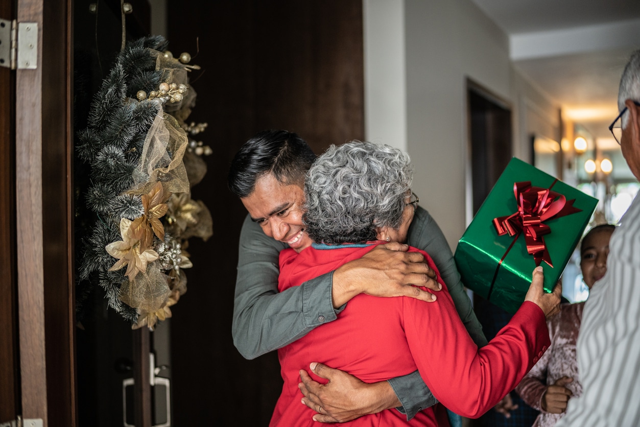 Man hugging a woman after giving her a holiday gift.